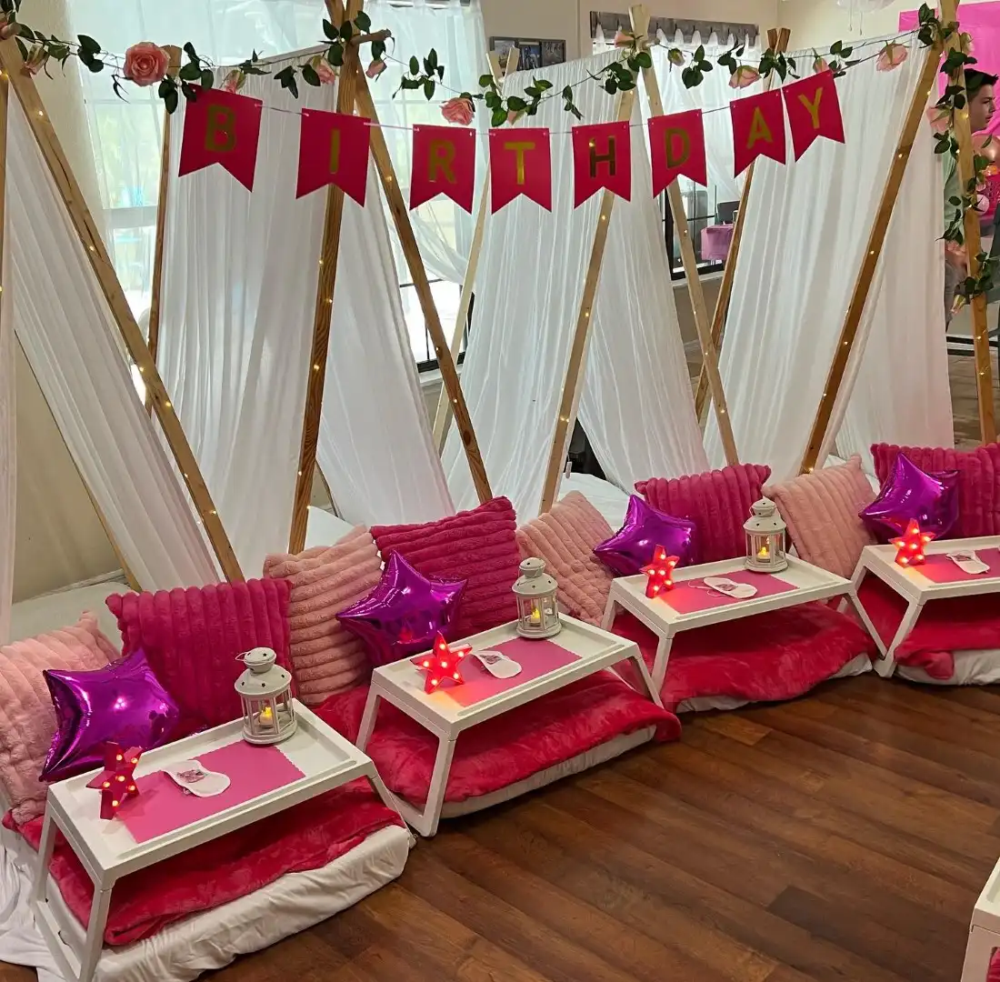 A room decorated with pink and white decorations for a BeeParty.