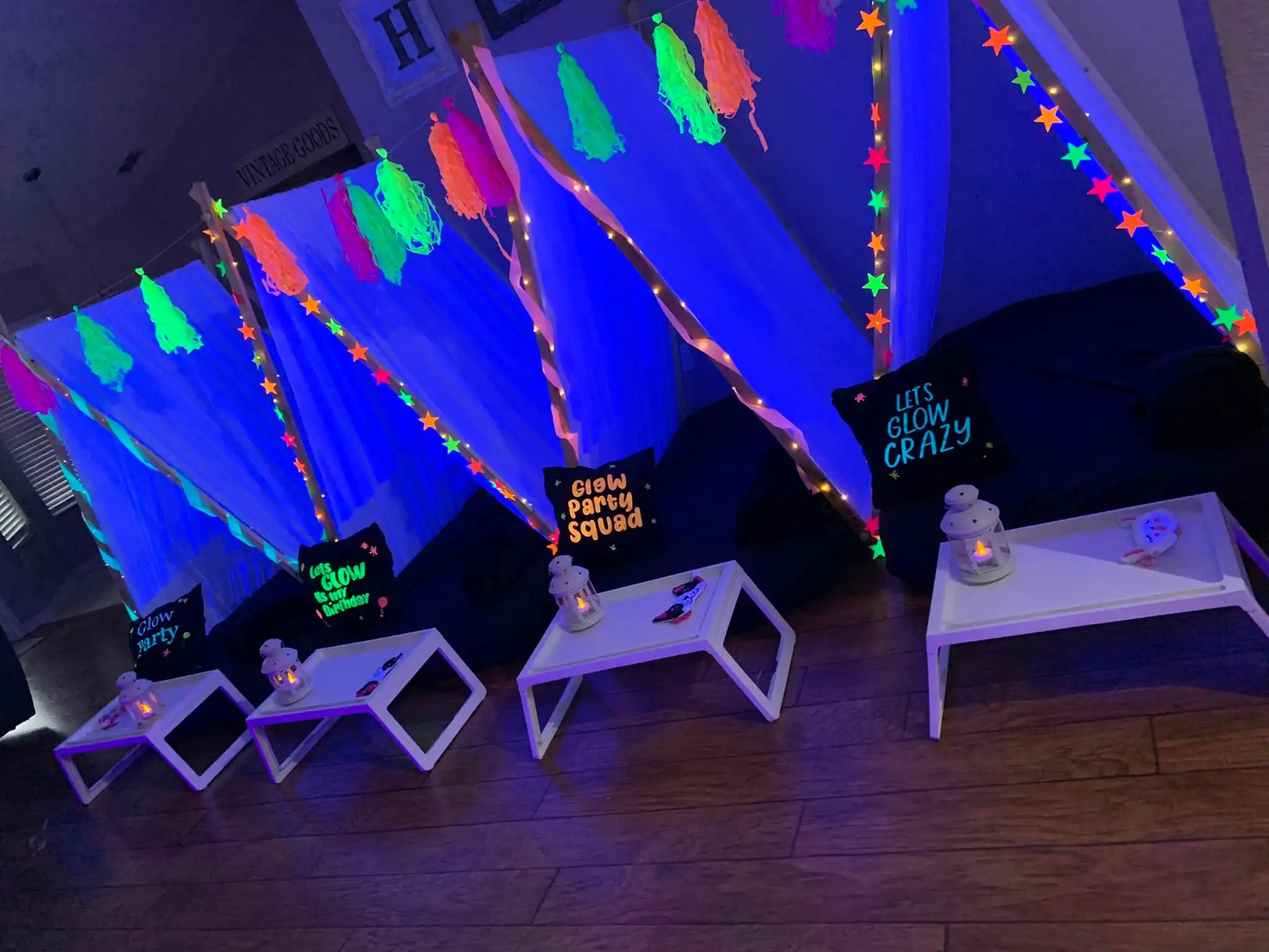 Teepee tents with lights, decorations, and an FAQ in a room.